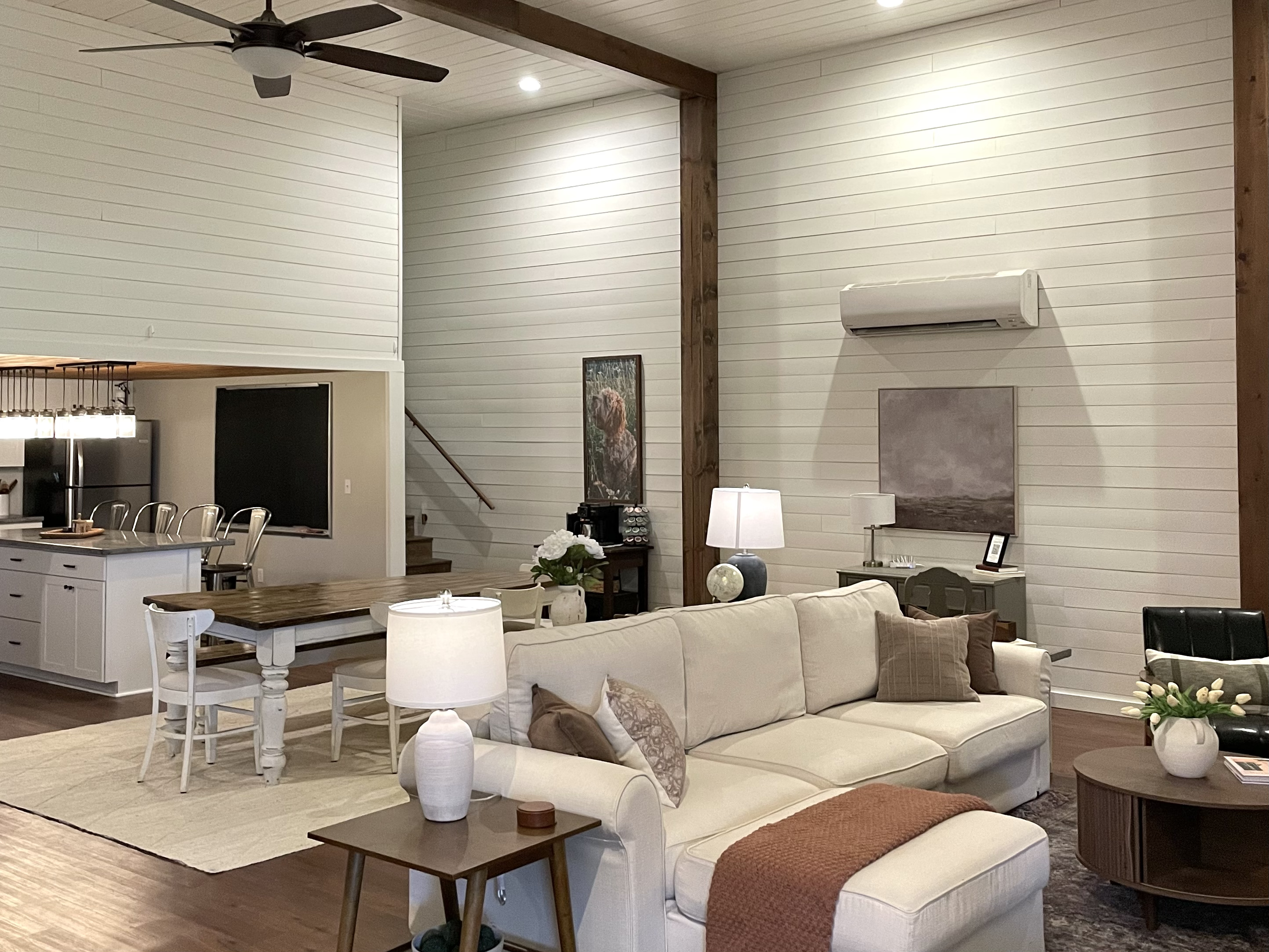 Open concept great room with high ceilings, cozy seating and a full kitchen, perfect for relaxing or gathering together.