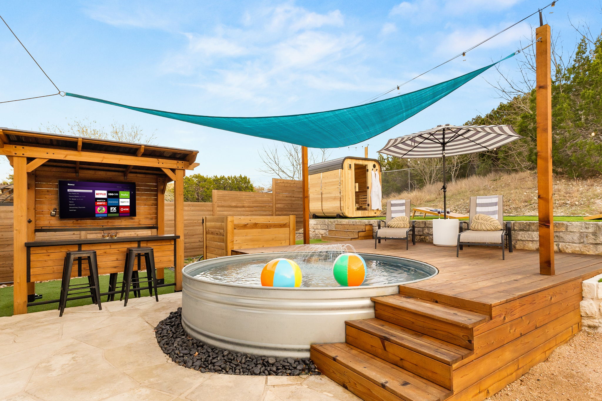 Your backyard wellness routine: sauna, cowboy pool, hot tub, repeat. Plus an outdoor entertainment setup for when you're done.