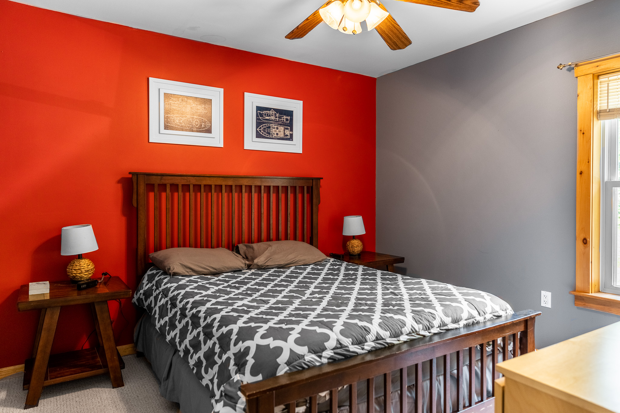Main floor bedroom with queen bed, ceiling fan, closet and dresser.