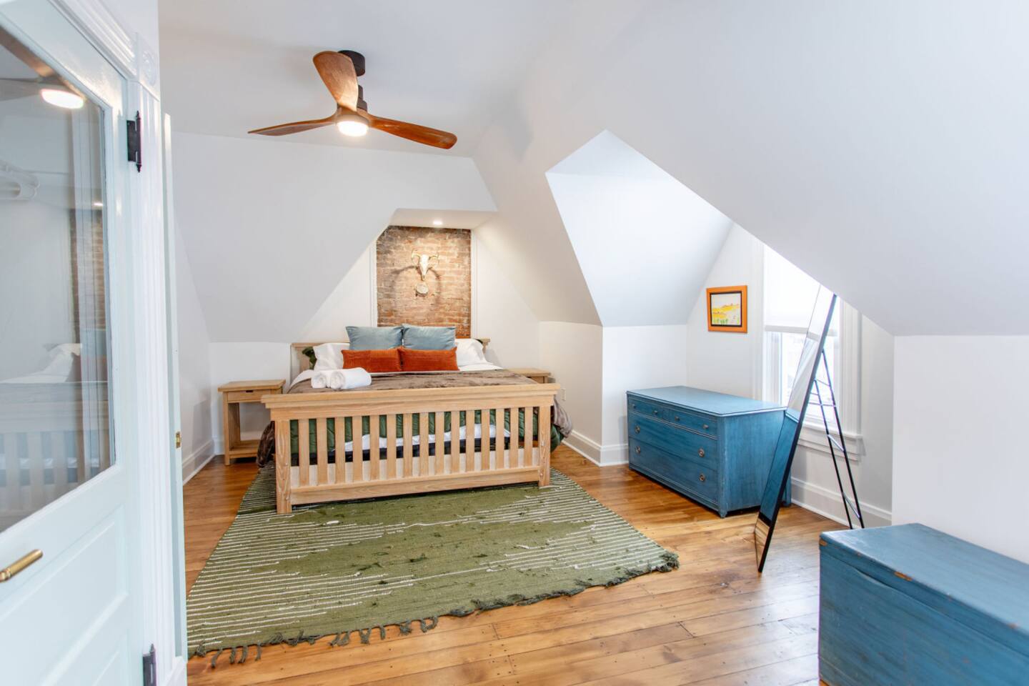 A spacious bedroom with a large window that fills the room with natural light, creating a bright and airy atmosphere perfect for relaxation.