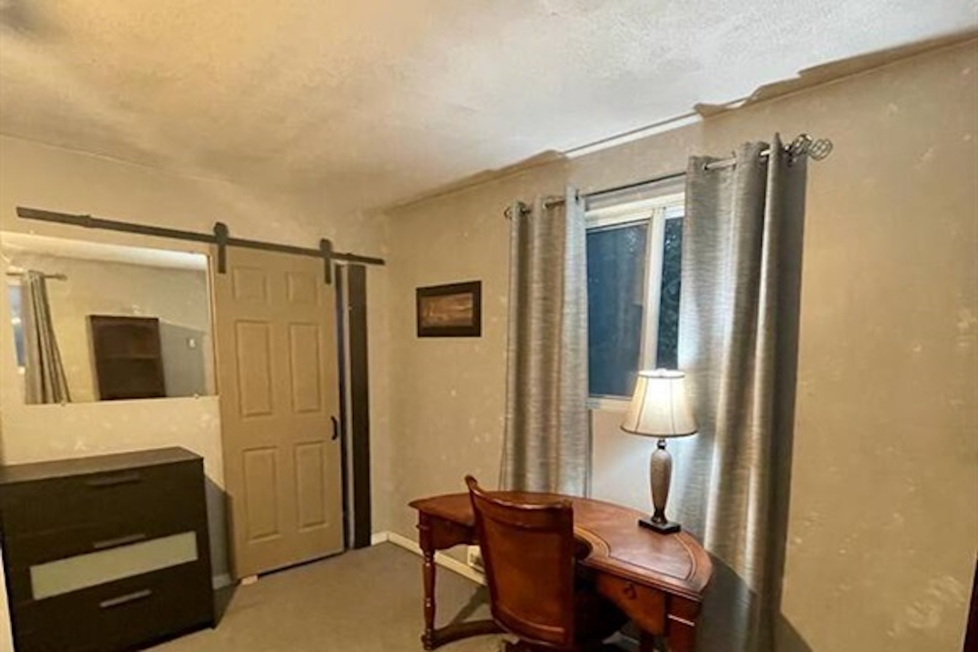 Bedroom with dresser, seating and natural light