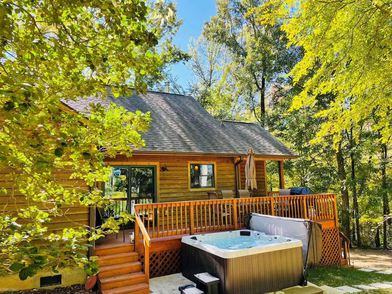 Back deck with dining table, grill, and hot tub