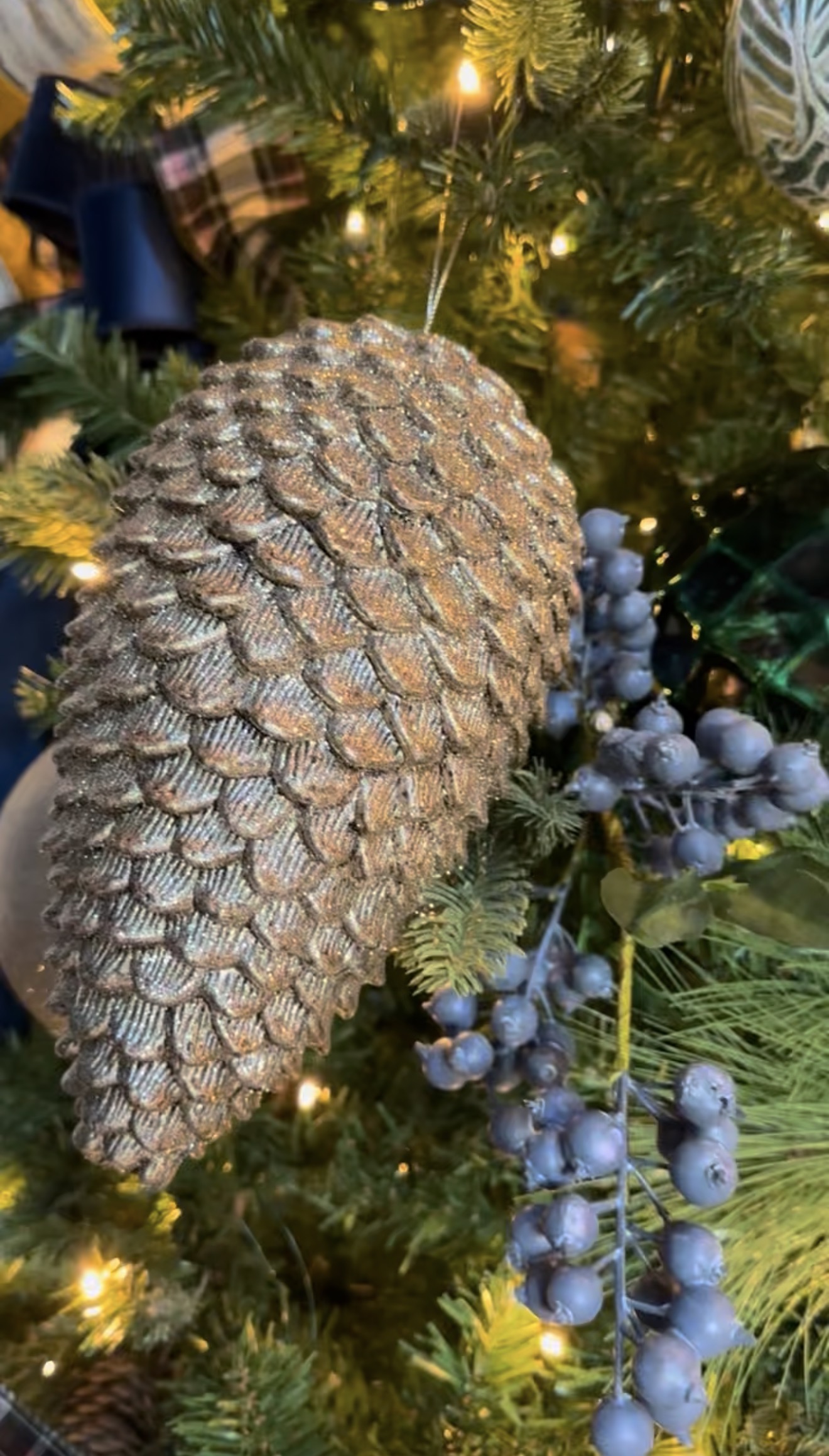 Rustic holiday décor—plaid ribbon, golden bells, and greenery—bringing festive charm to our Broken Bow cabin. 🌲✨