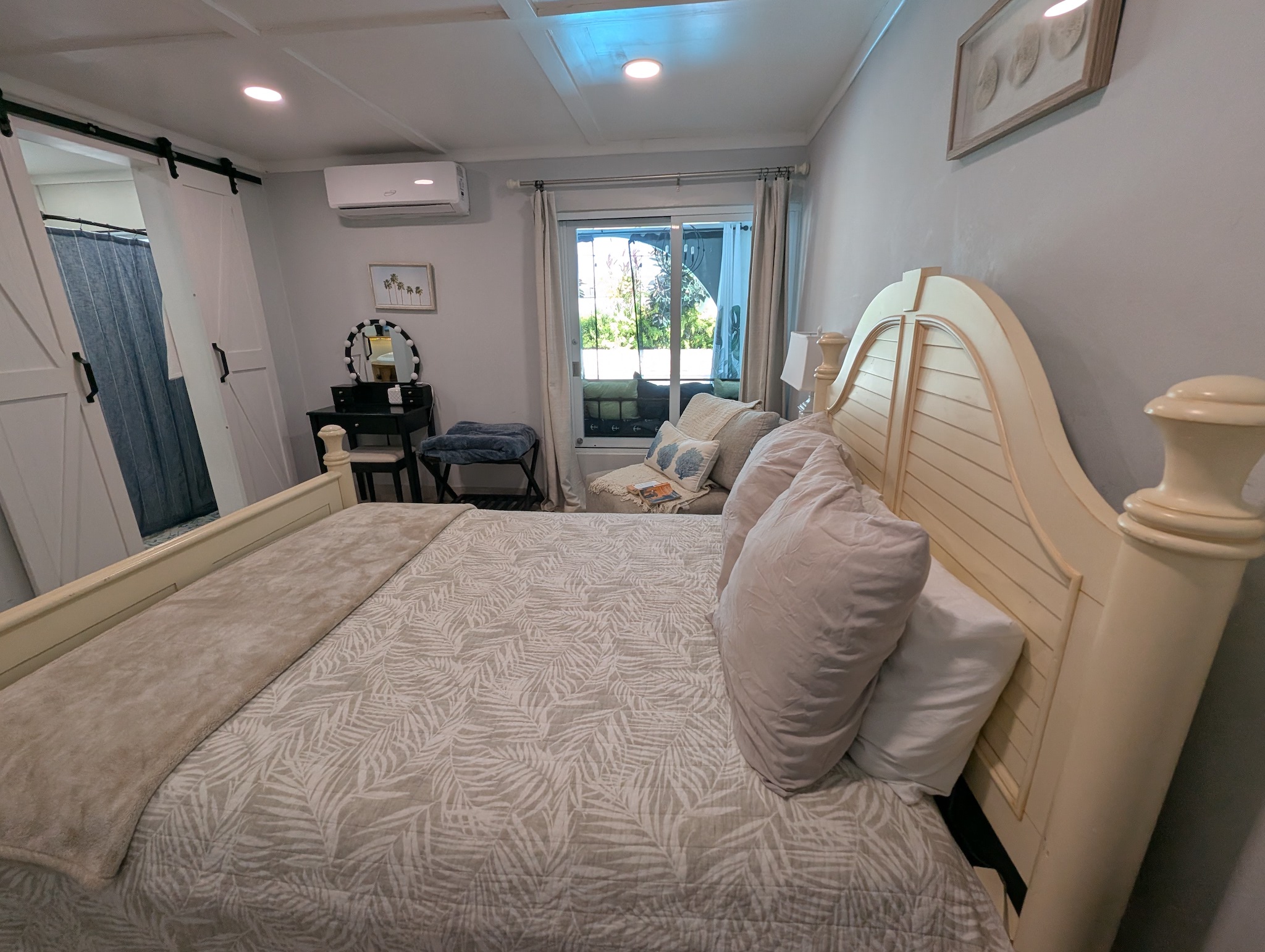 Bright queen bedroom at Villa Coral featuring an adjustable motorized bed base, vanity station, and lovely view to the pool in Dorado, Puerto Rico.
