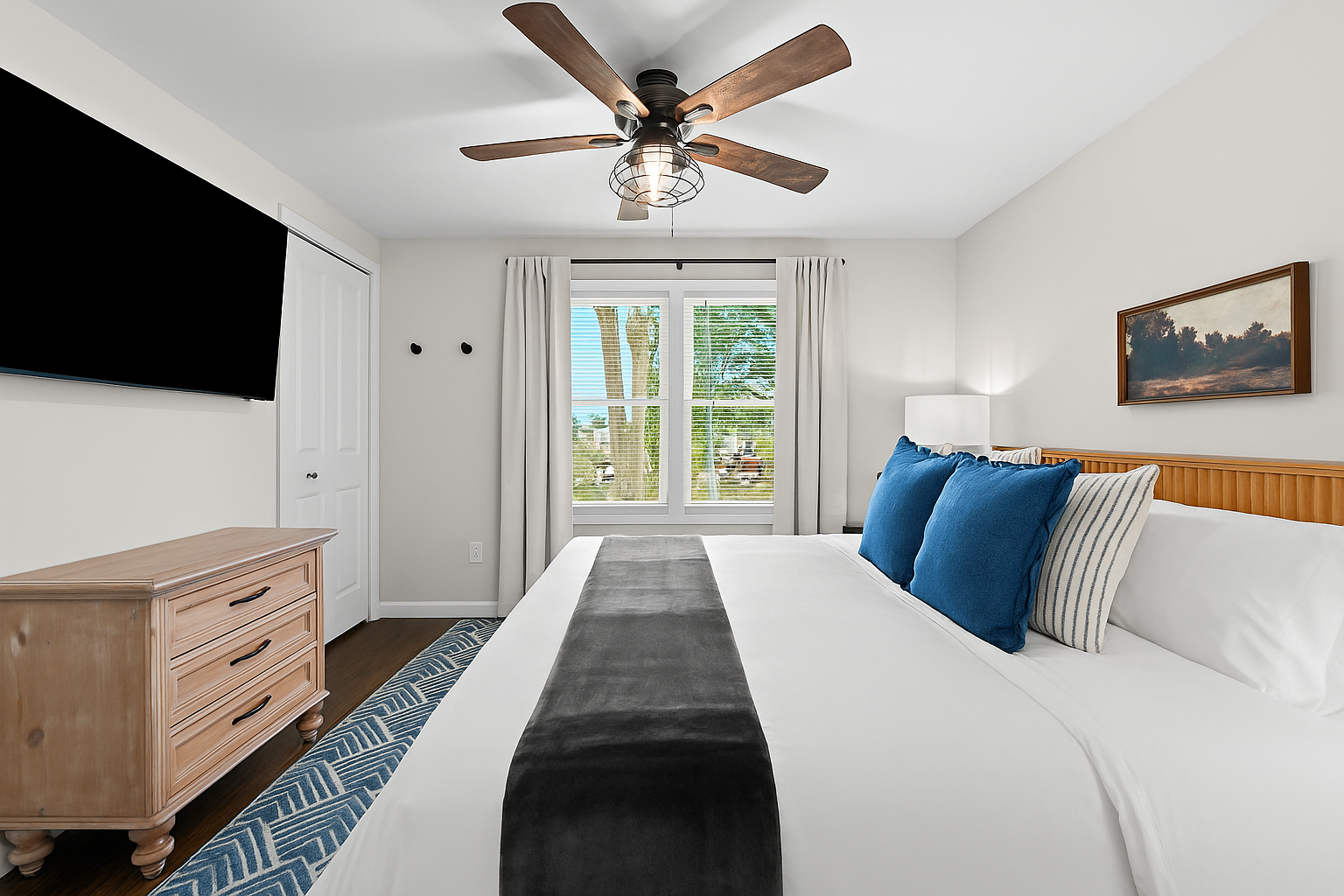 Bright and airy bedroom with a king bed, Smart TV, ceiling fan, and peaceful views.