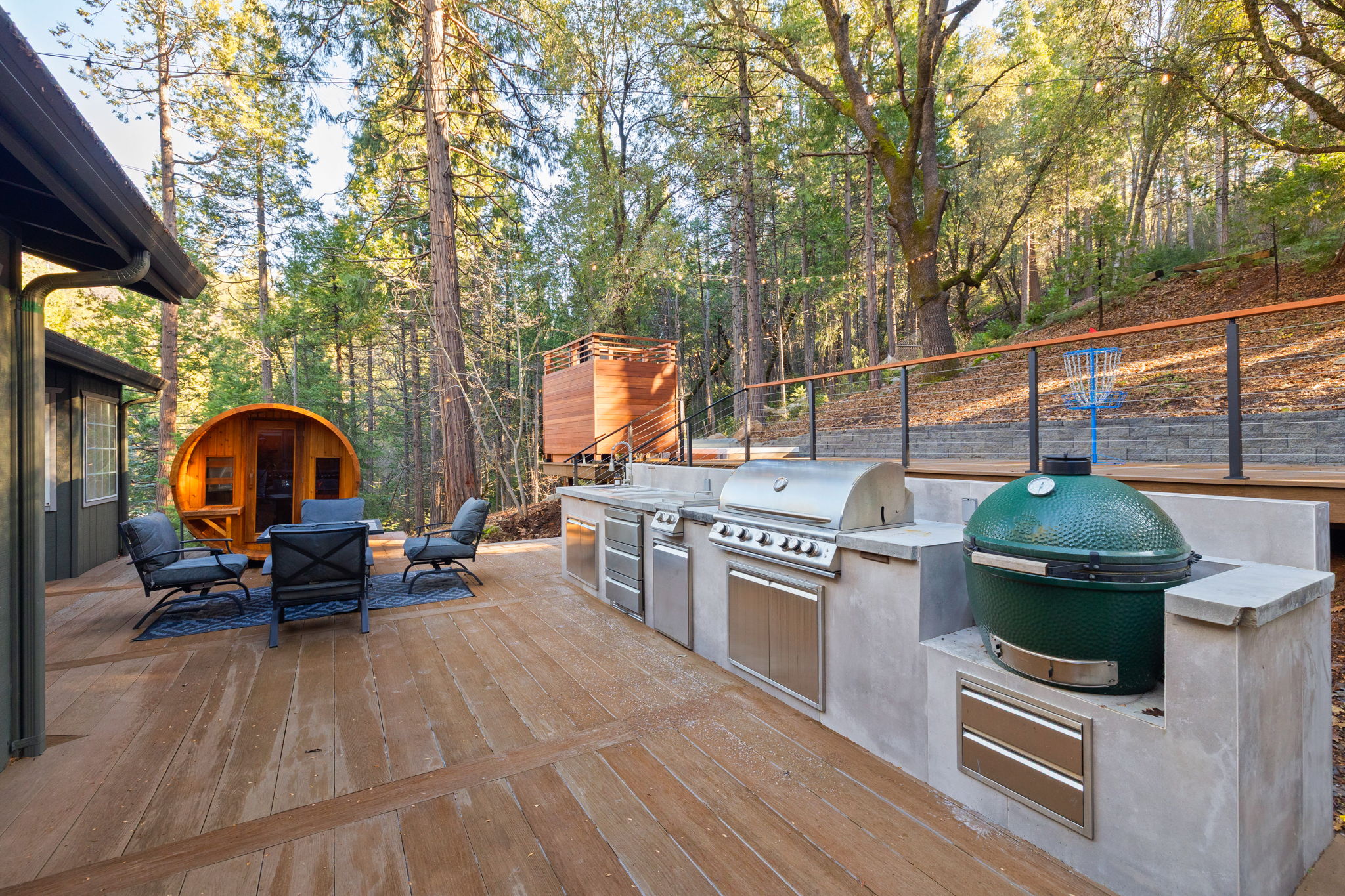 Outdoor kitchen with dual decks. Sauna and outdoor shower also pictured.