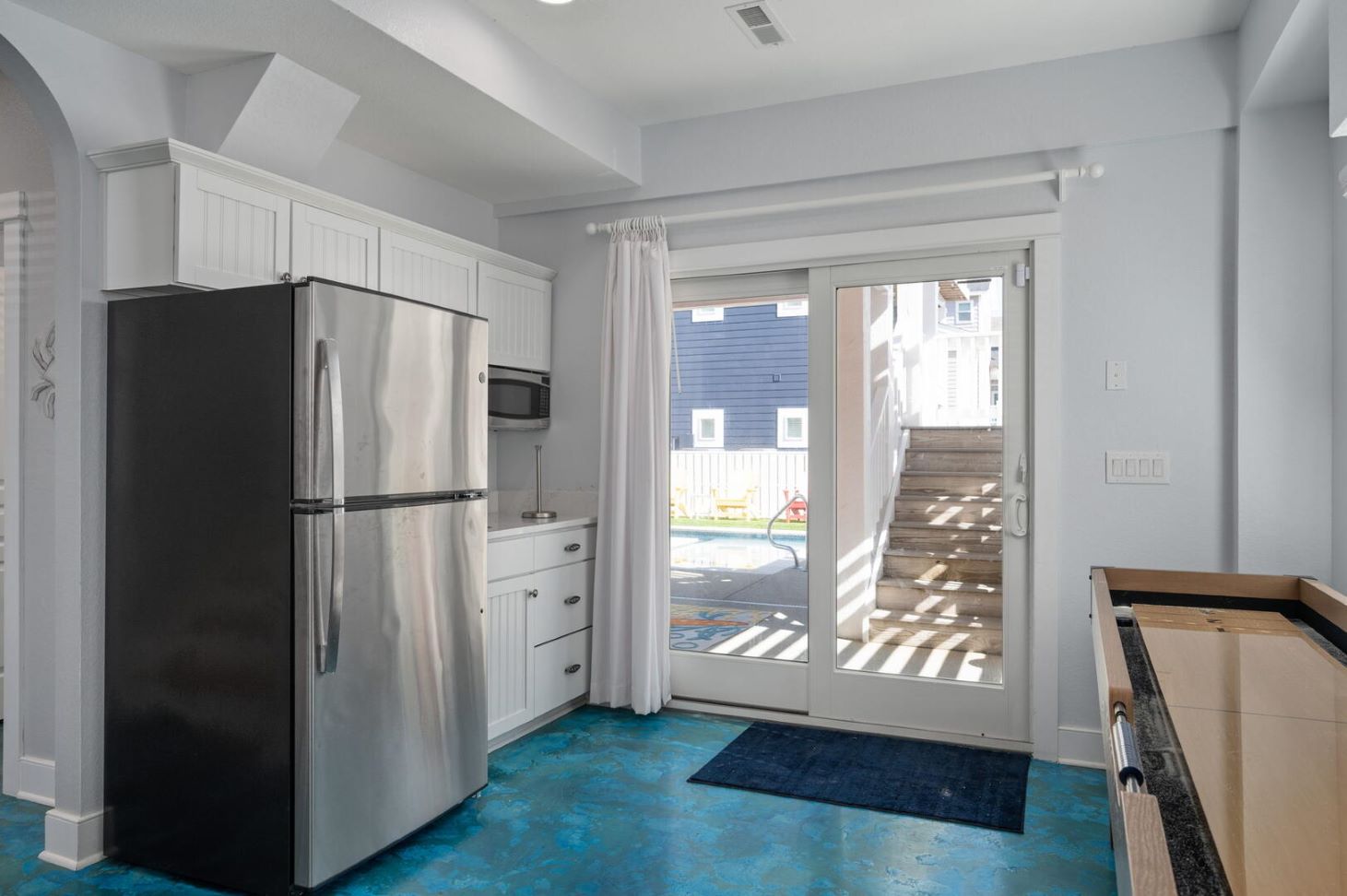 Fridge with ice maker, microwave, bar sink.  Sliding door access to pool area with door alarm.