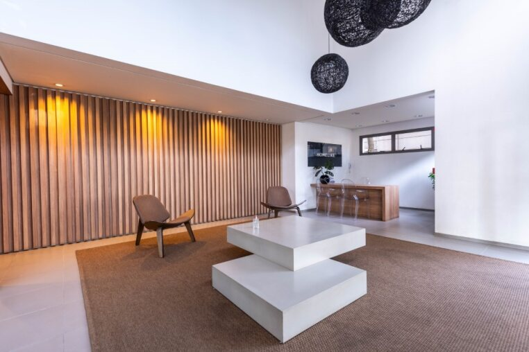 Lobby moderno com portaria 24h - Entrada elegante do condomínio com design contemporâneo — experiência premium desde a chegada.