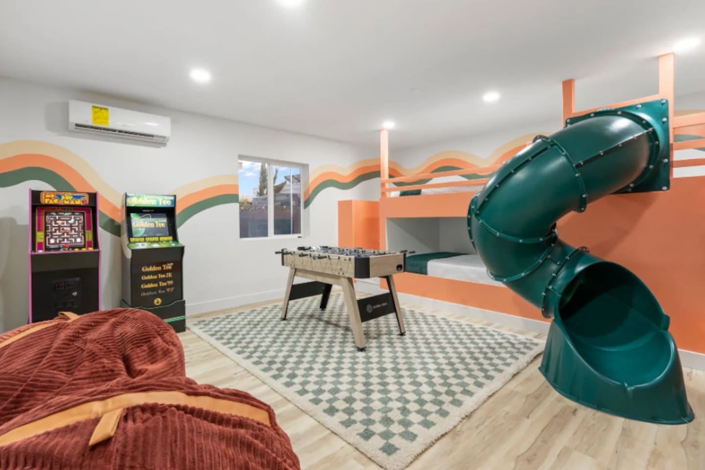A dedicated game room brings the fun indoors too, with a slide, bunk beds, foosball, and classic arcade cabinets all in one colorful space.
