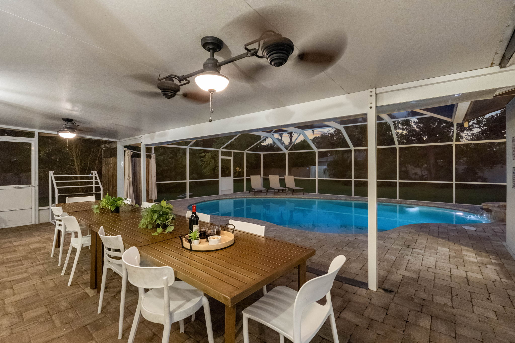 The screened-in pool deck offers a private retreat, combining lush greenery with a refreshing swimming pool.
