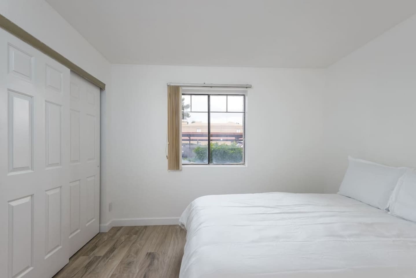 Queen bedroom with clean bedding, a floor lamp, and a simple setup for a good night’s rest.
