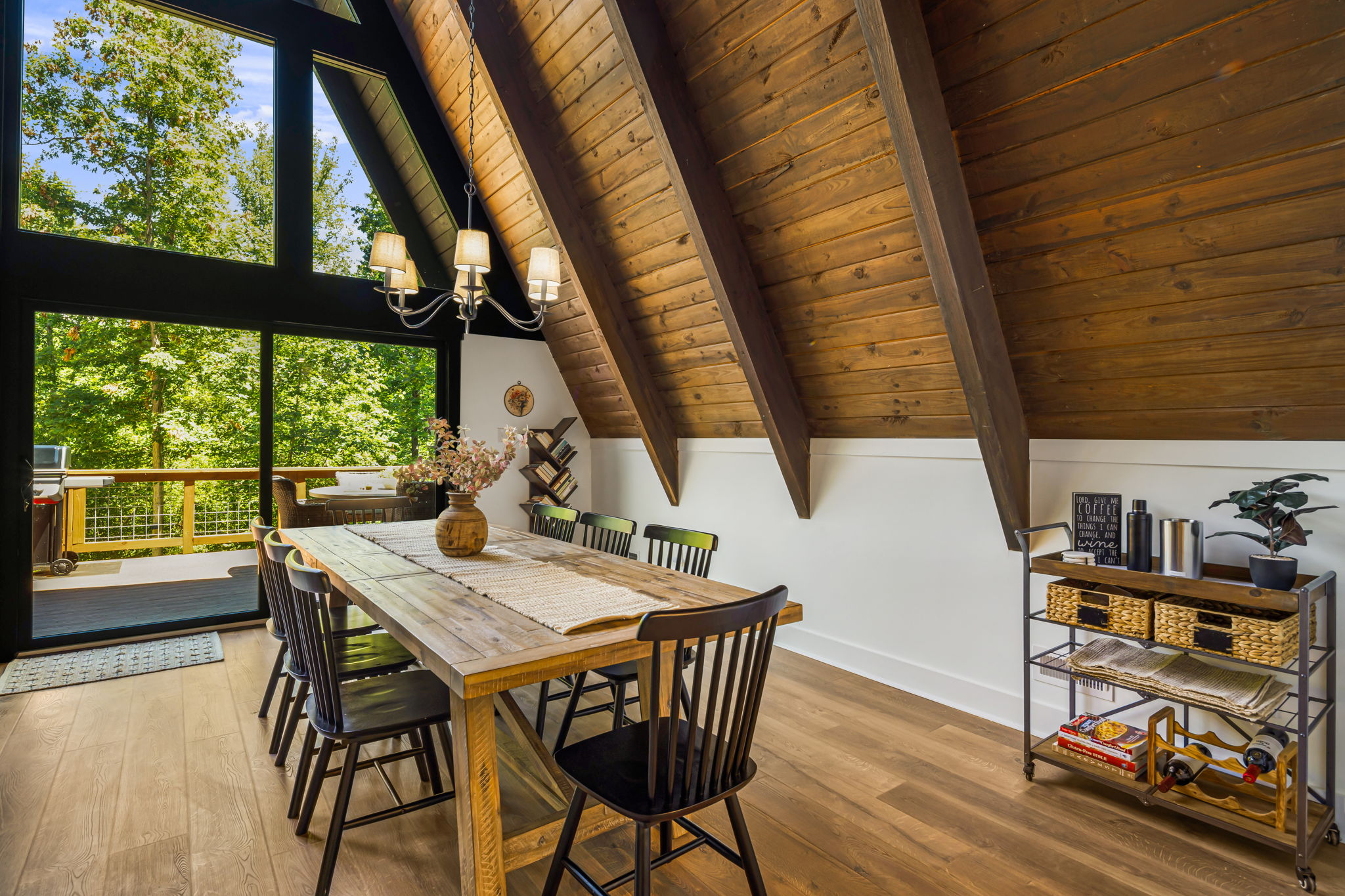 The spacious dining area has a large table with seating for 8. This is in addition to the 4 spaces also available at the kitchen island. Comfy chairs, a chandelier and all the essential dinnerware you'll need. Placemats and a mobile cart within reach.