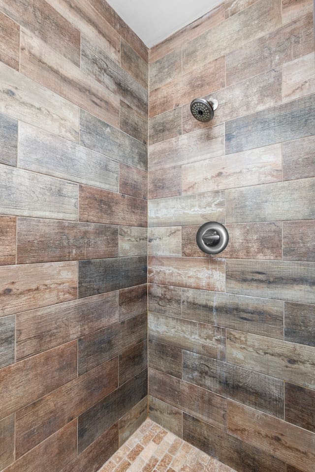 Step into this stylish full bathroom featuring a spacious walk-in shower with custom wood-look tile and frameless glass door for a spa-like experience.

