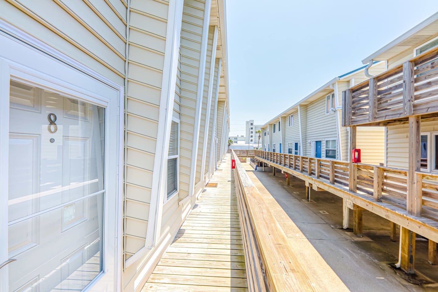 Exterior Walkway: Step into beachside bliss along our scenic wooden walkway! Sunlit views await.