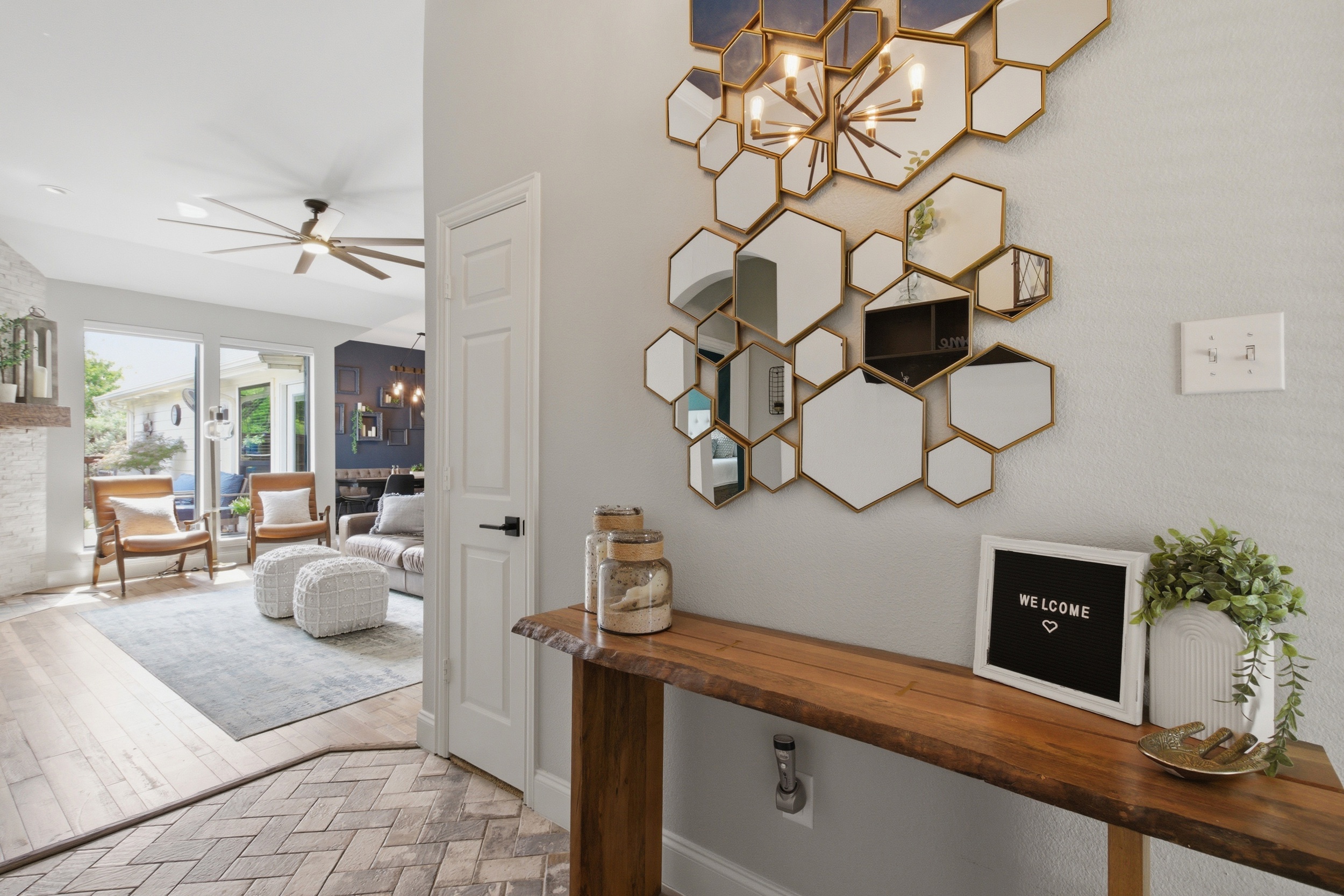 Step inside the open foyer that flows directly into the spacious main living area. A custom hexagon mirror feature wall, console table, and bright natural light set the tone for your stay.