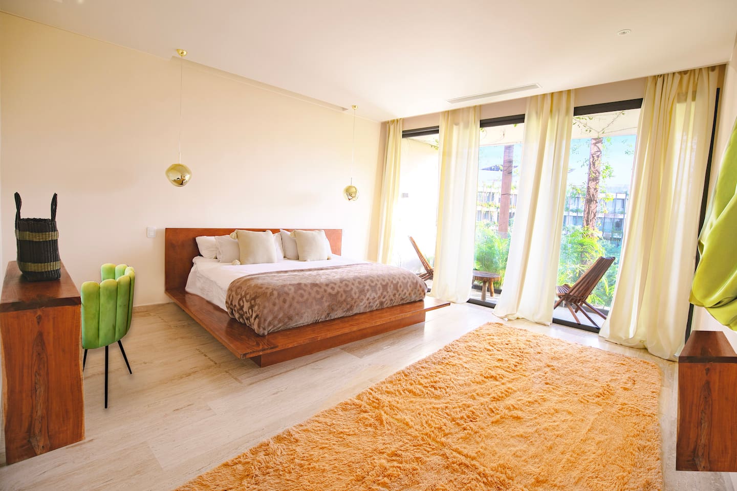 King sized bed in a large room with a desk area, private balcony and local art. 