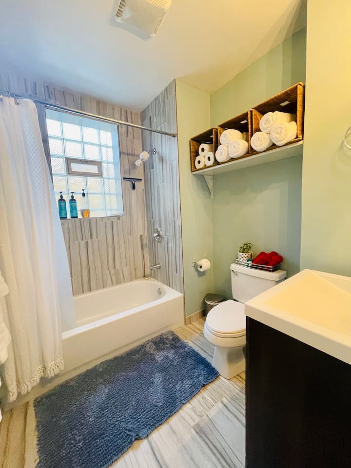 Bathroom with full bathtub and fully stocked