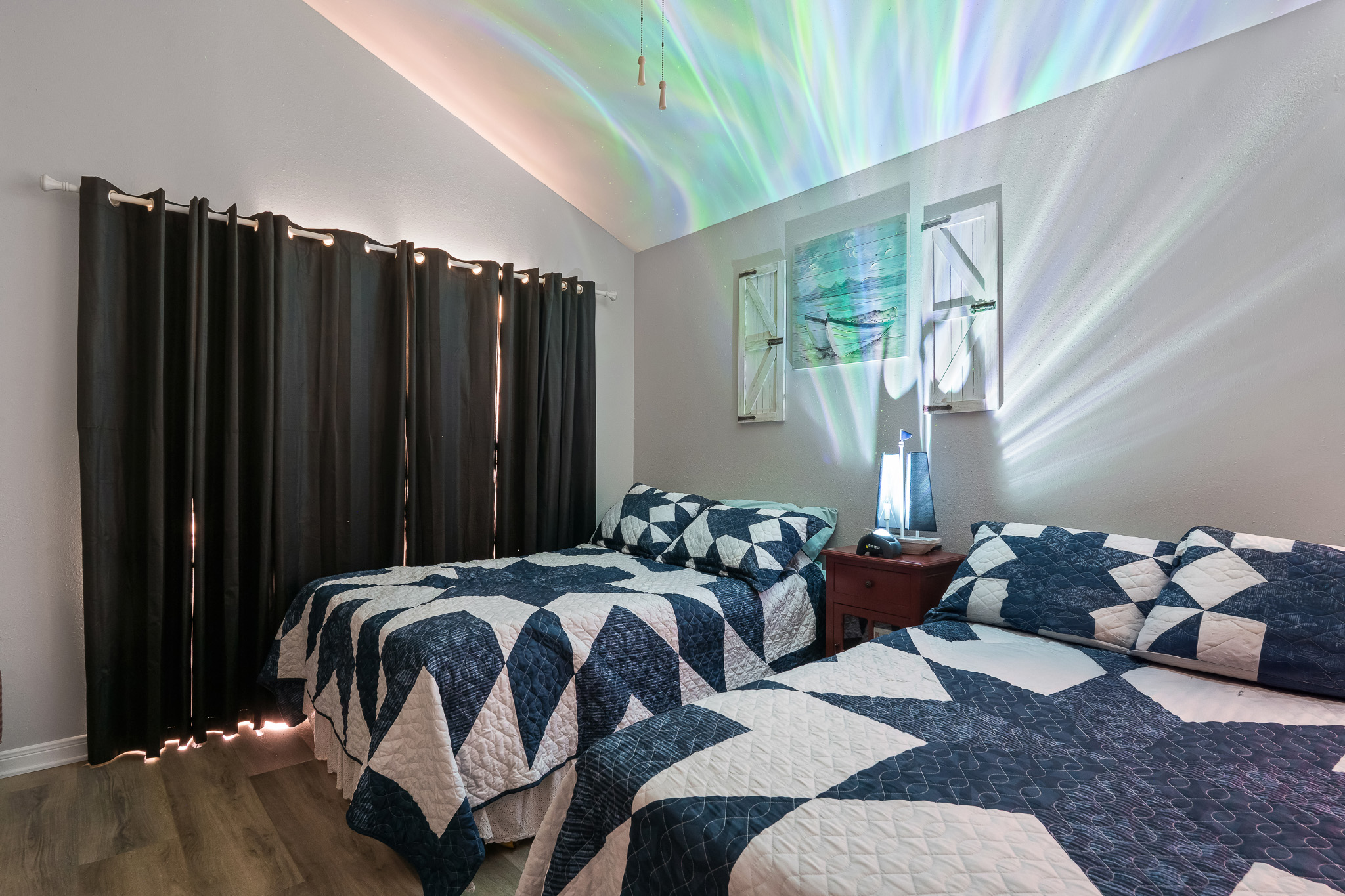 Unwind in this dreamy double-queen room featuring a Rossetta Galaxy Projector with soothing star lights, white noise, Bluetooth speaker, and remote—ideal for kids, or anyone needing a peaceful sleep.