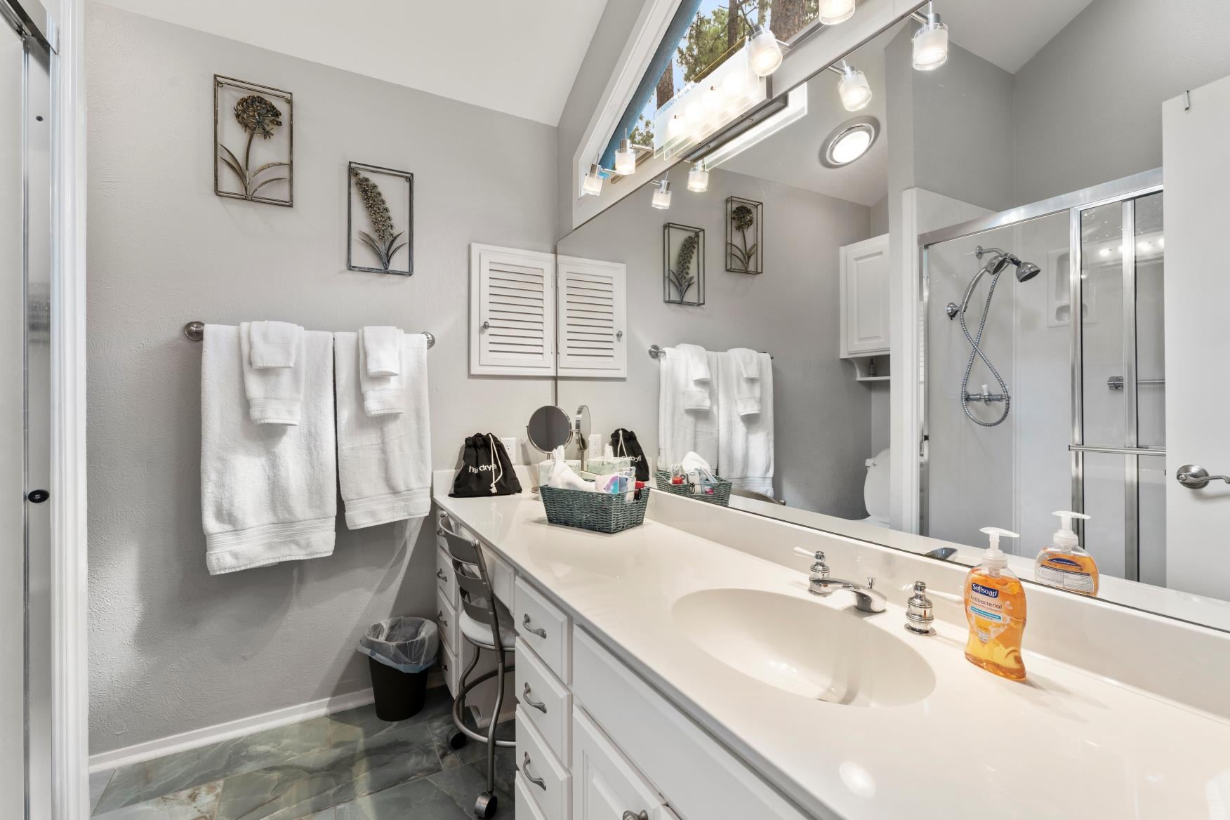 King 2 Bathroom features a walk-in shower, a thoughtful basket filled with essentials, and stunning views through its unique, eye-catching windows.