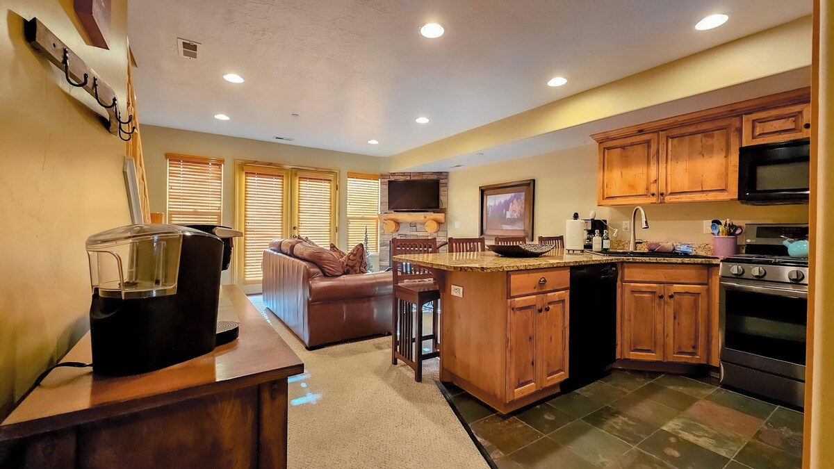 The gourmet kitchen features breakfast bar with seating and is equipped with appliances, including a microwave, gas stove, and spacious refrigerator.
