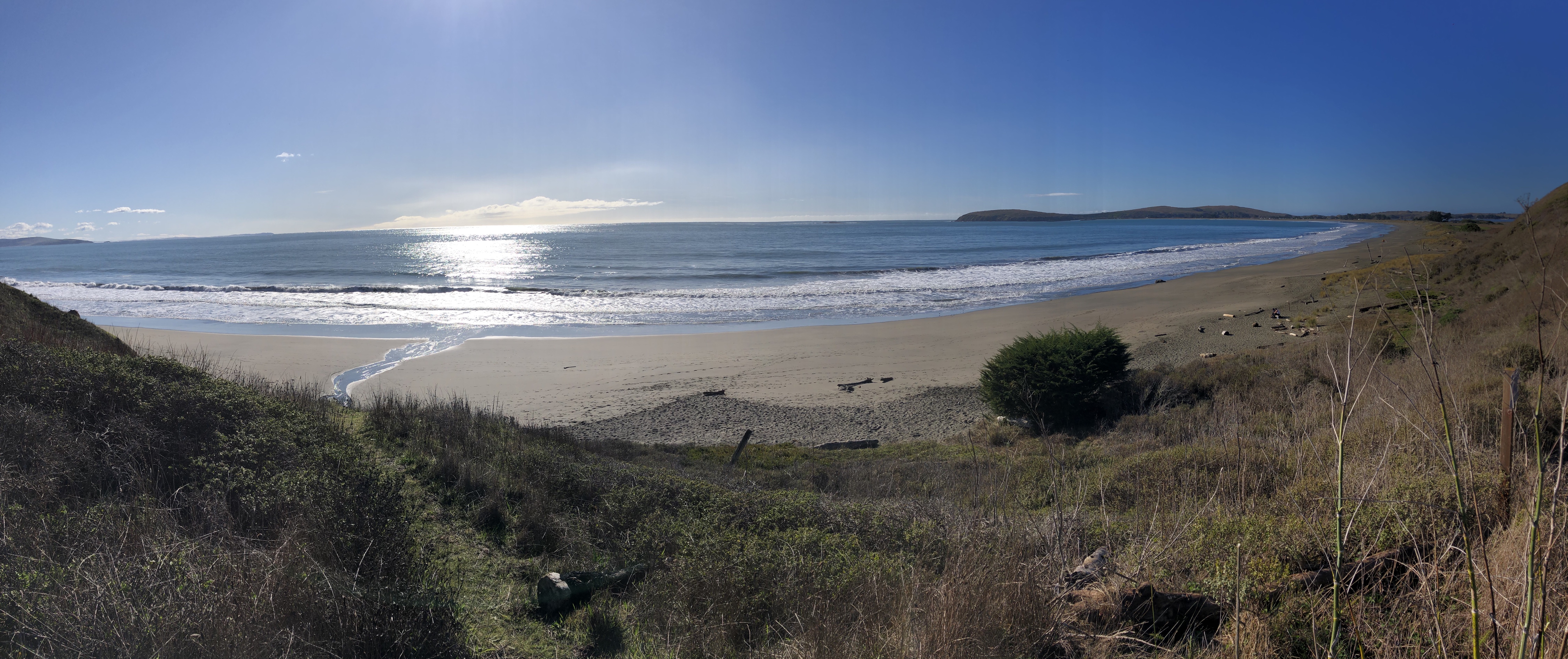 Wide view of the beach with sunlight on the ocean