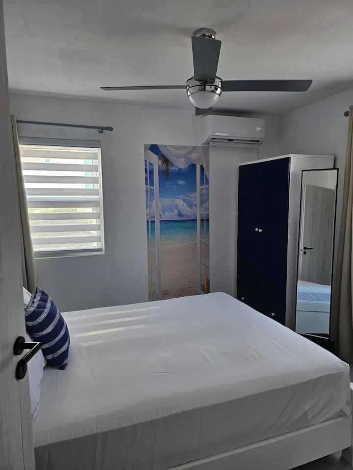 Queen size bed, new mattress, full length mirror, darkening curtains, A/C, ceiling fan, and wardrobe