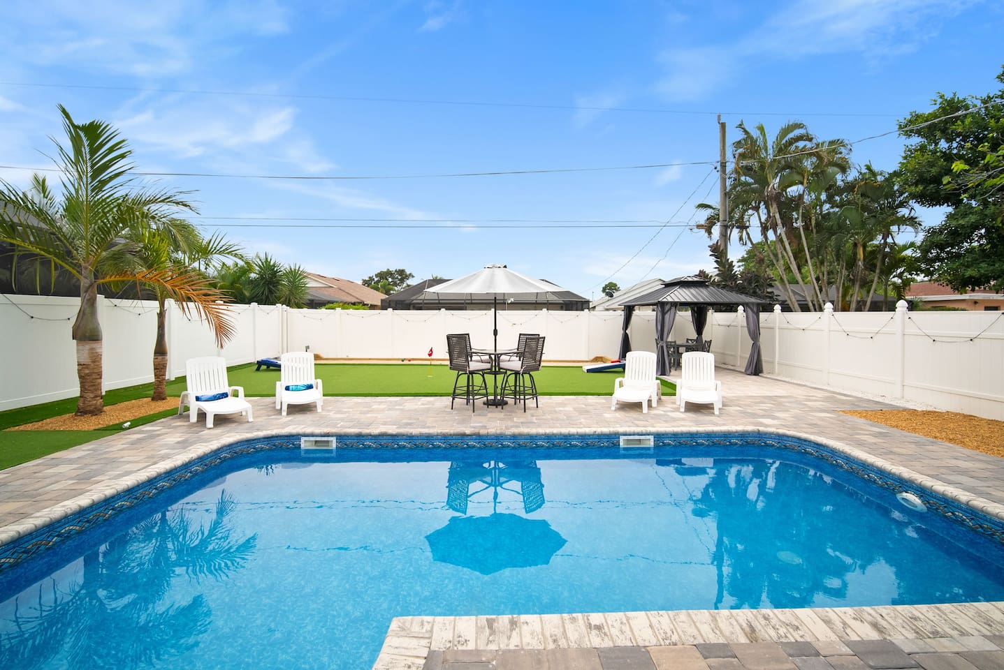 Pool, lounge chairs, and the gazebo in the back with the ceiling fan