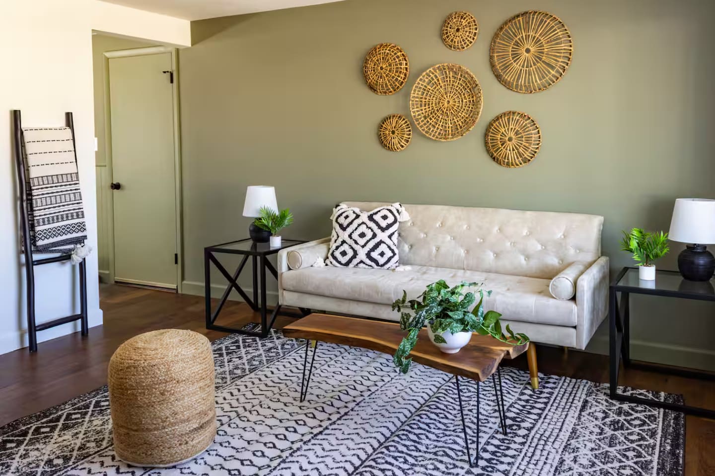 Warm olive walls, woven wall art, and a plush sofa make this living room feel like a curated escape.