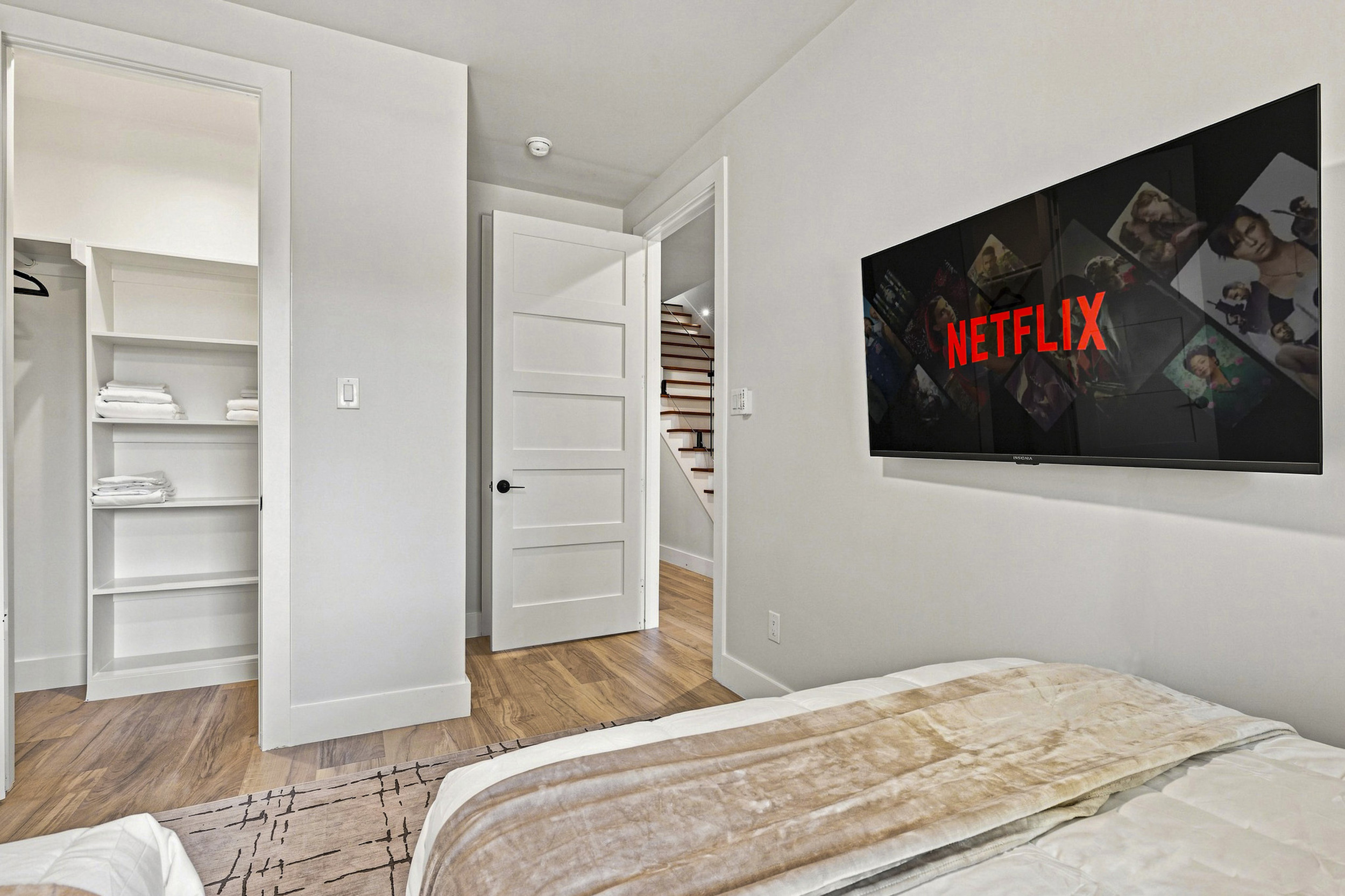 Enjoy movie nights in style with a sleek TV and plush bedding!