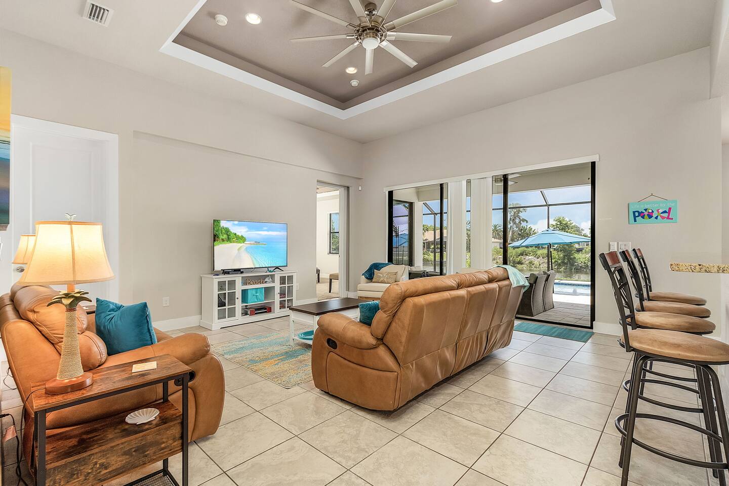 Spacious living room with captivating views of the pool and water