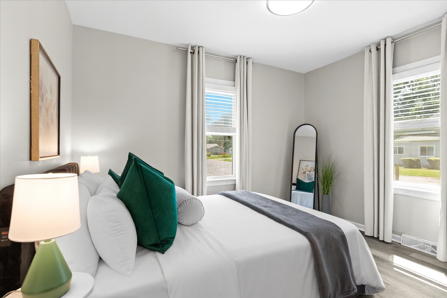 Bedroom with queen bed, nightstand, and full-length mirror