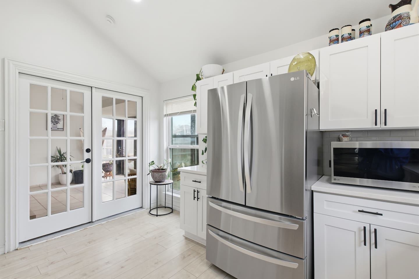 Kitchen with stainless refrigerator, pantry storage, and access to the sunroom for natural light and easy entertaining.