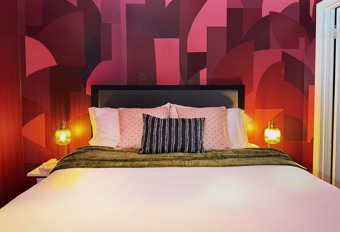 The principal (queen) bedroom with en suite bathroom doesn't whisper — it announces itself. Bold murals, warm vintage lighting & boutique-hotel energy. Minutes from the Quarter, but this room might be the destination.