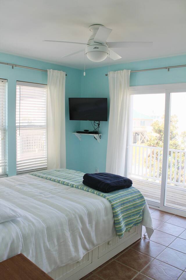 2nd floor guest bedroom #2, back of house. Balcony access. Queen bed. TV. Dresser for clothes storage.