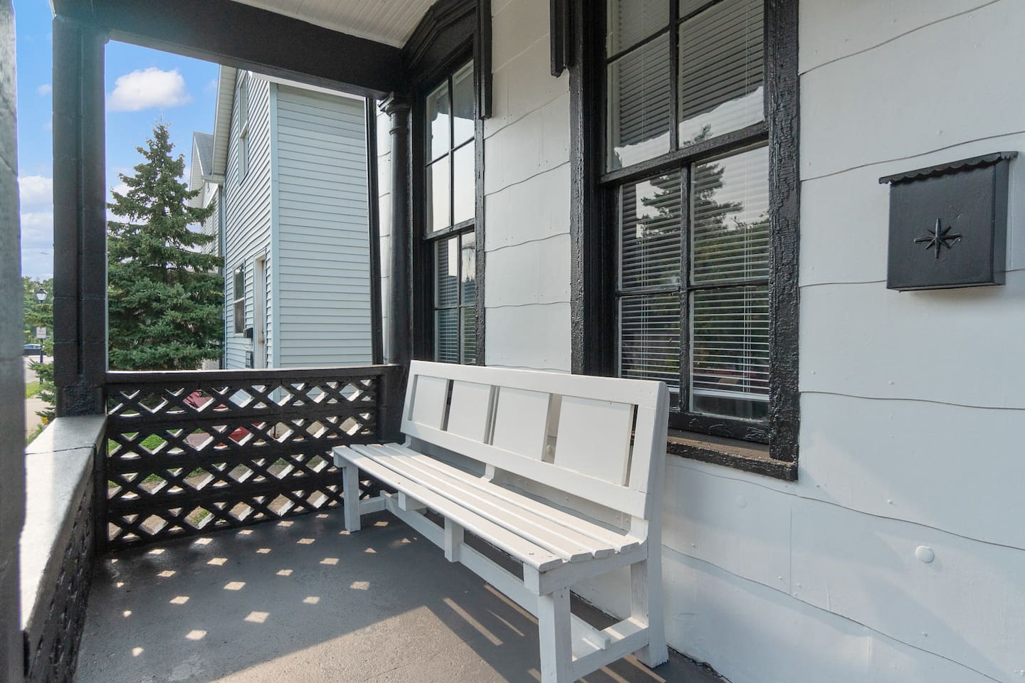 Cozy front porch with comfortable seating furniture, perfect for relaxing and enjoying the fresh air while taking in the view of the surrounding space.