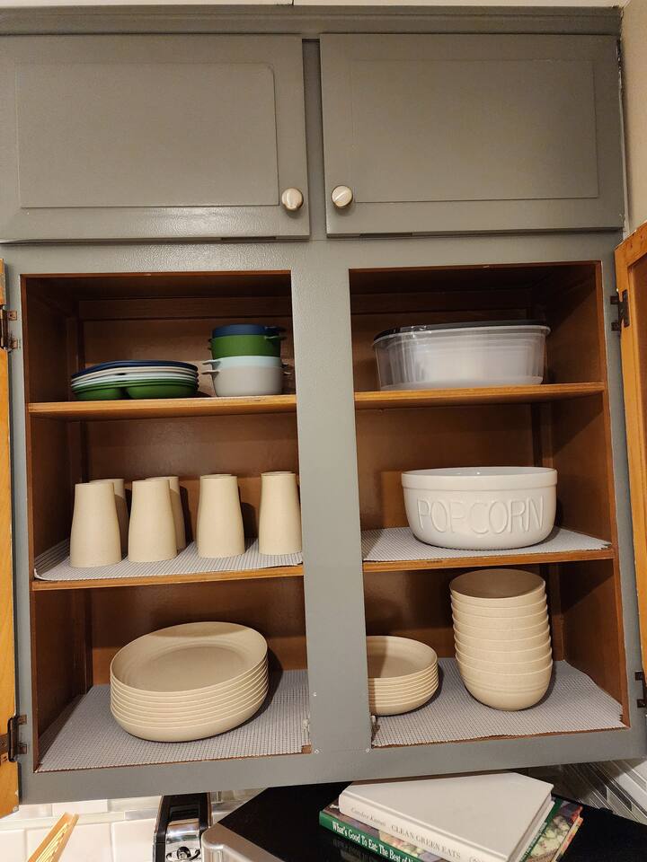 Kitchen stocked full of regular and plastic dishes for outdoor usage.