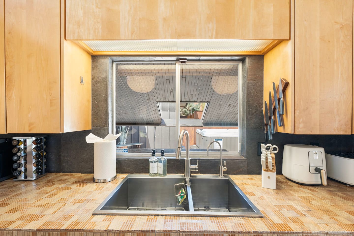 Clean and modern double sink station with sleek fixtures, warm wood cabinetry, and fully equipped countertops for everyday convenience.