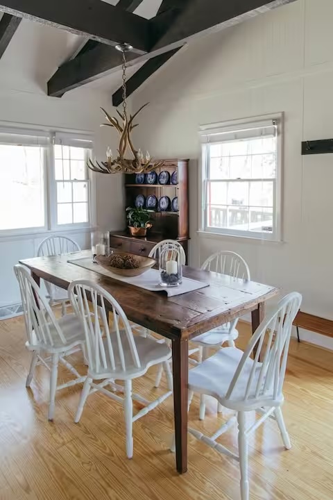 Gather around the farmhouse table beneath reclaimed beams and antler chandeliers.