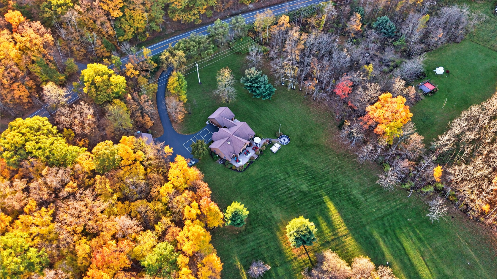 Expansive lawn surrounded by colorful autumn woodland