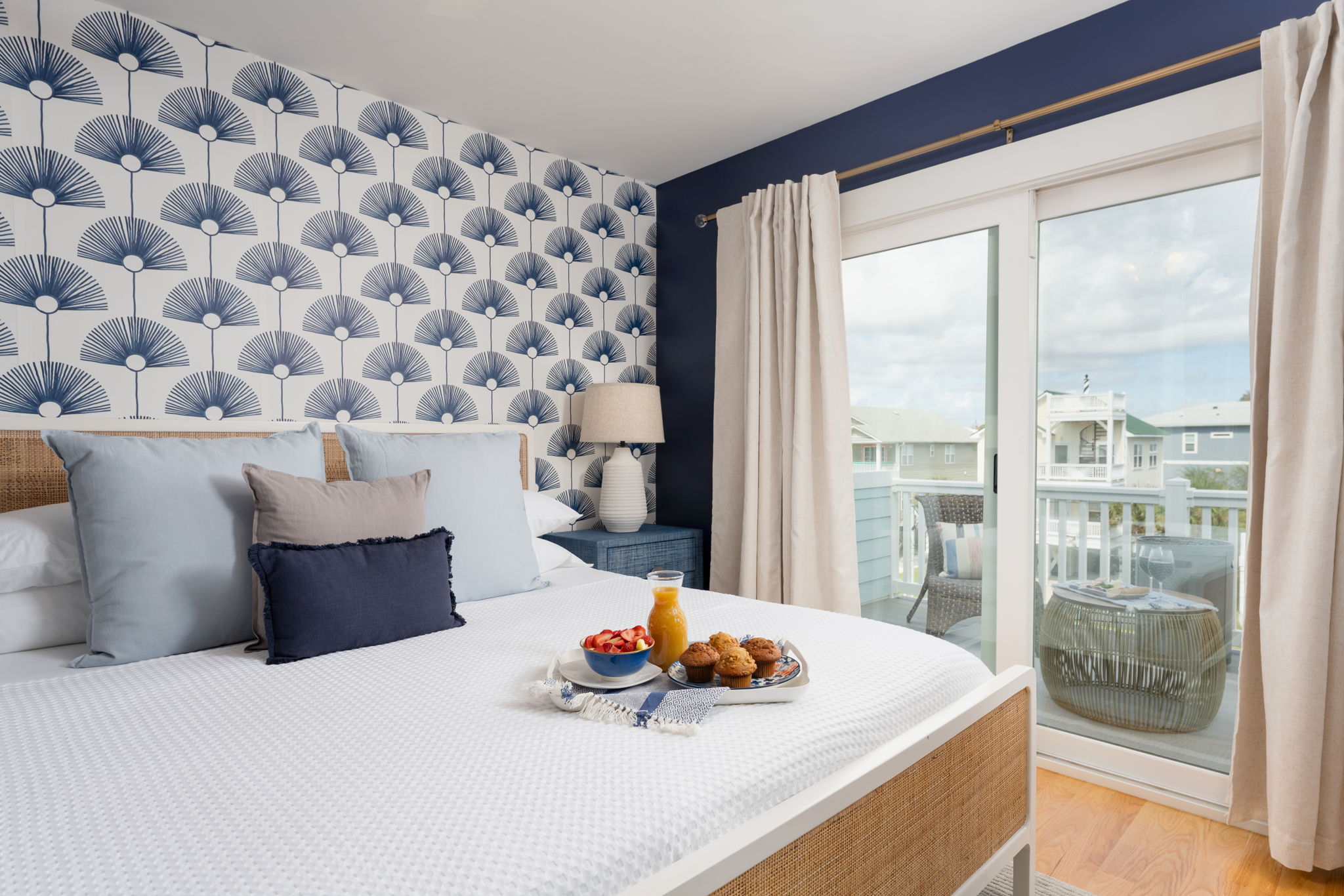 Third-floor king suite with sliding doors to a private balcony overlooking the neighborhood.