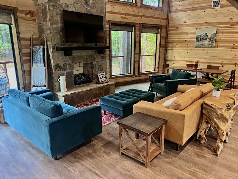 Soaring windows frame the pond outside while warm wood and stone invite you to gather and relax.
