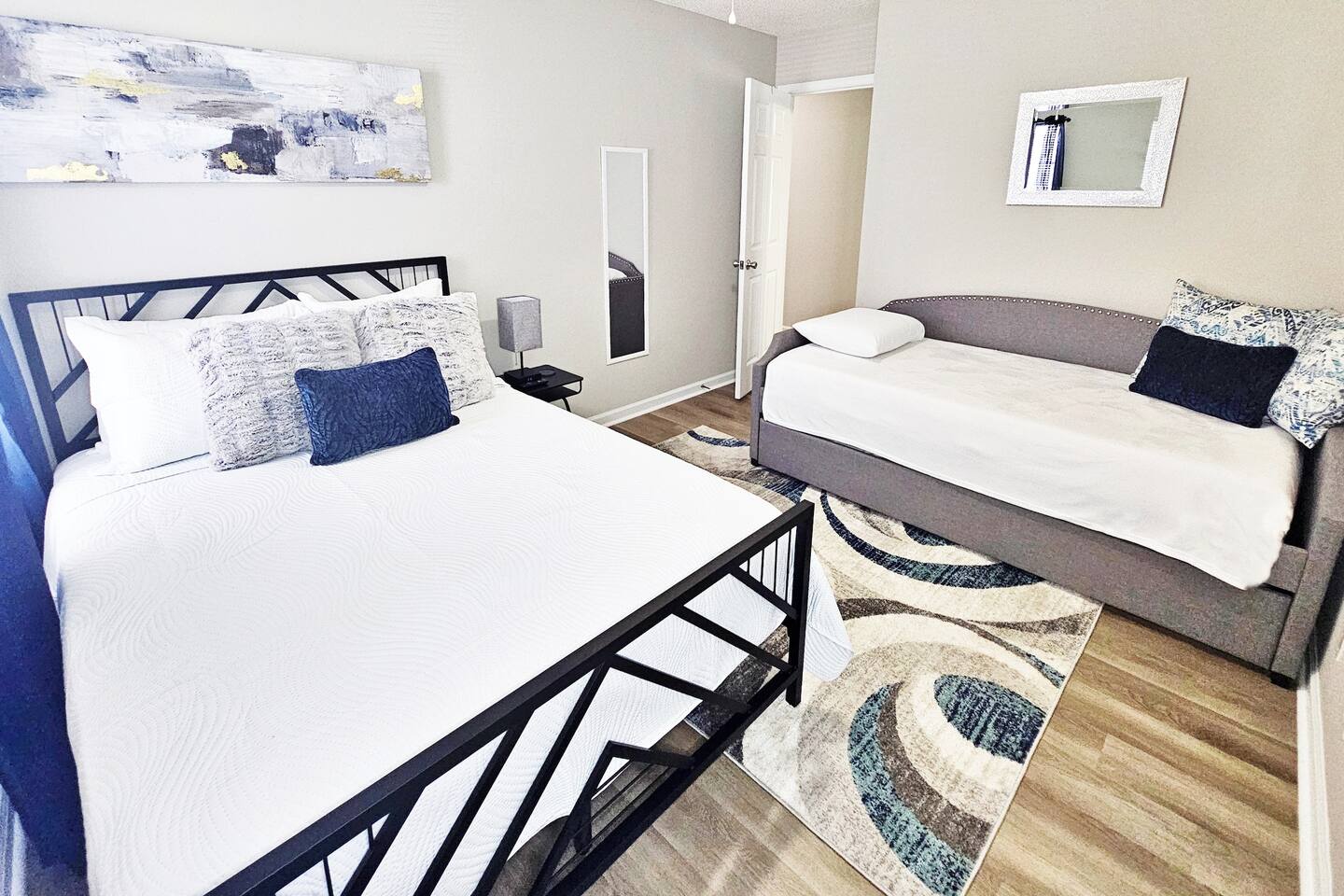 This serene bedroom can sleep up to 4 adults. Full-length mirror and flat screen smart TV in here as well!