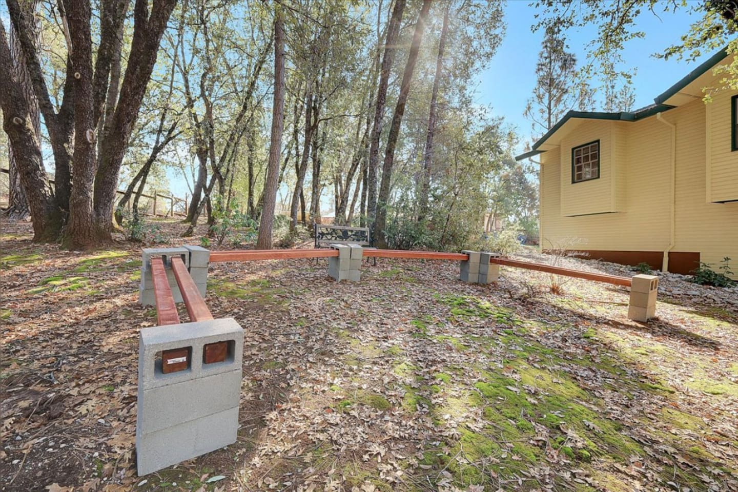 Wooded outdoor area with simple bench seating and a quiet spot to enjoy the trees.
