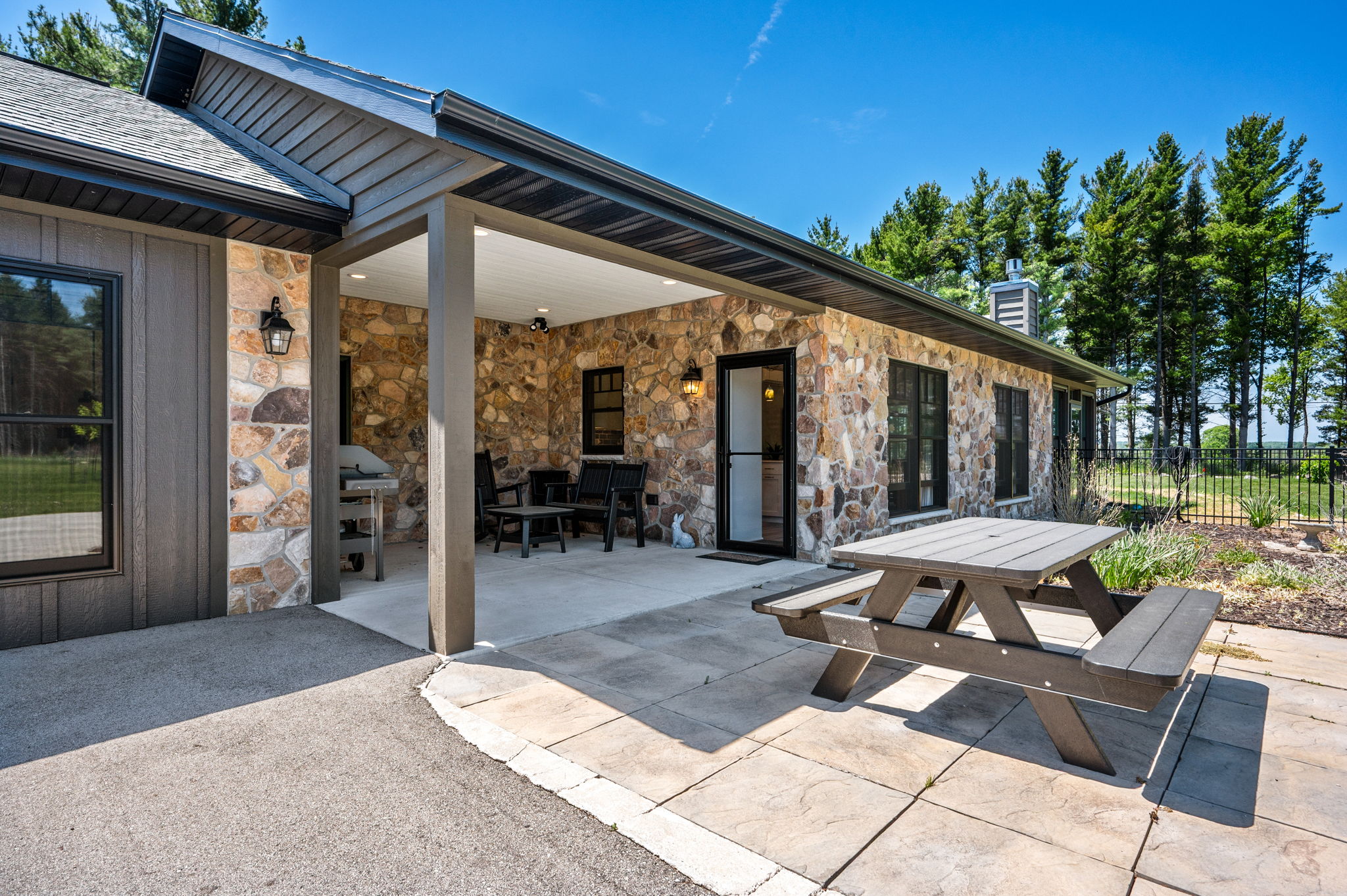 Fire up the grill and dine al fresco on the covered stone patio, outfitted with a picnic table and comfortable seating for lazy summer evenings.