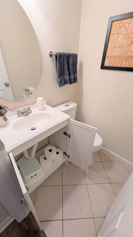 Half bath has plenty of toilet paper, hand soap, fresh towels, and a step stool for children. 
