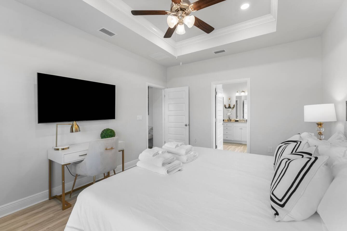Enjoy comfort and style with a bright bedroom, cozy lamps, and a ceiling fan.