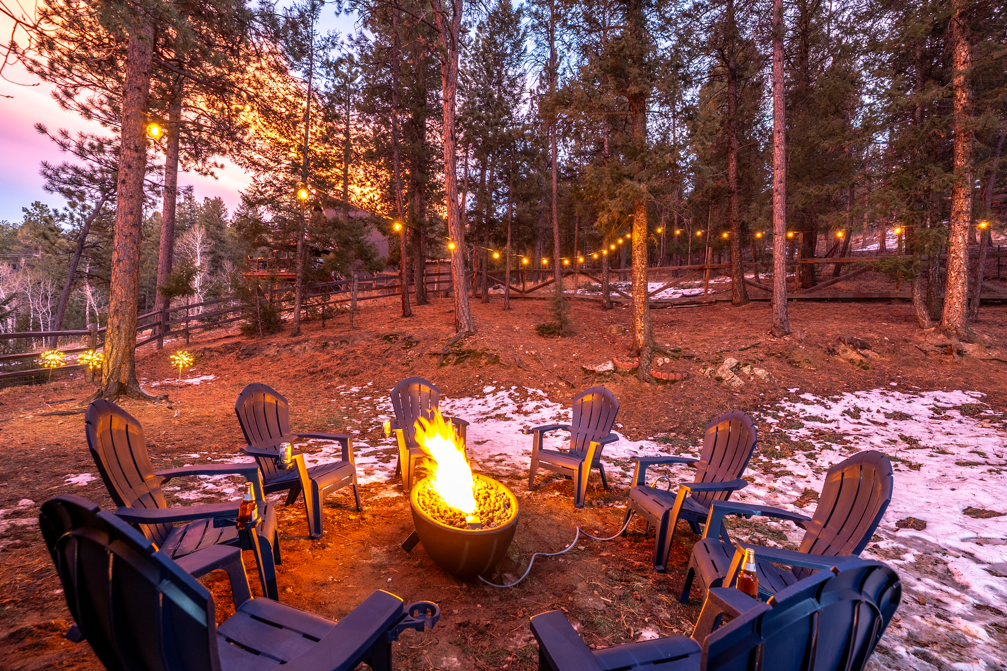 🔥✨ Evening firepit glow—Adirondack chairs under twinkle lights, pine trees all around, and plenty of room for s’mores, stories, and stargazing 🌲🌌