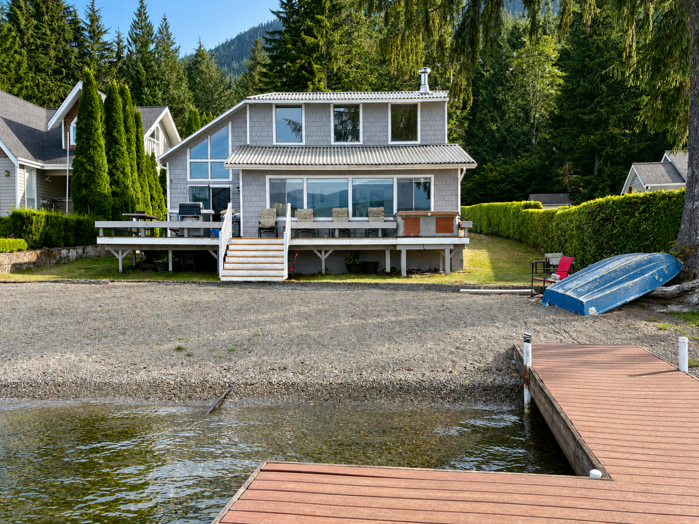 Exterior view of the house overlooking the sandy beach and private dock, with beautiful lake views and easy access to the water.