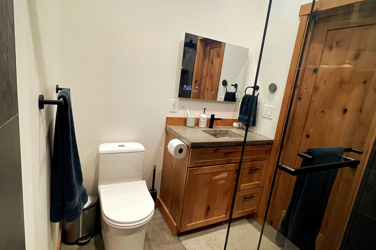 Master bathroom with dual shower heads, concrete countertops, and lighted mirror w/defogging