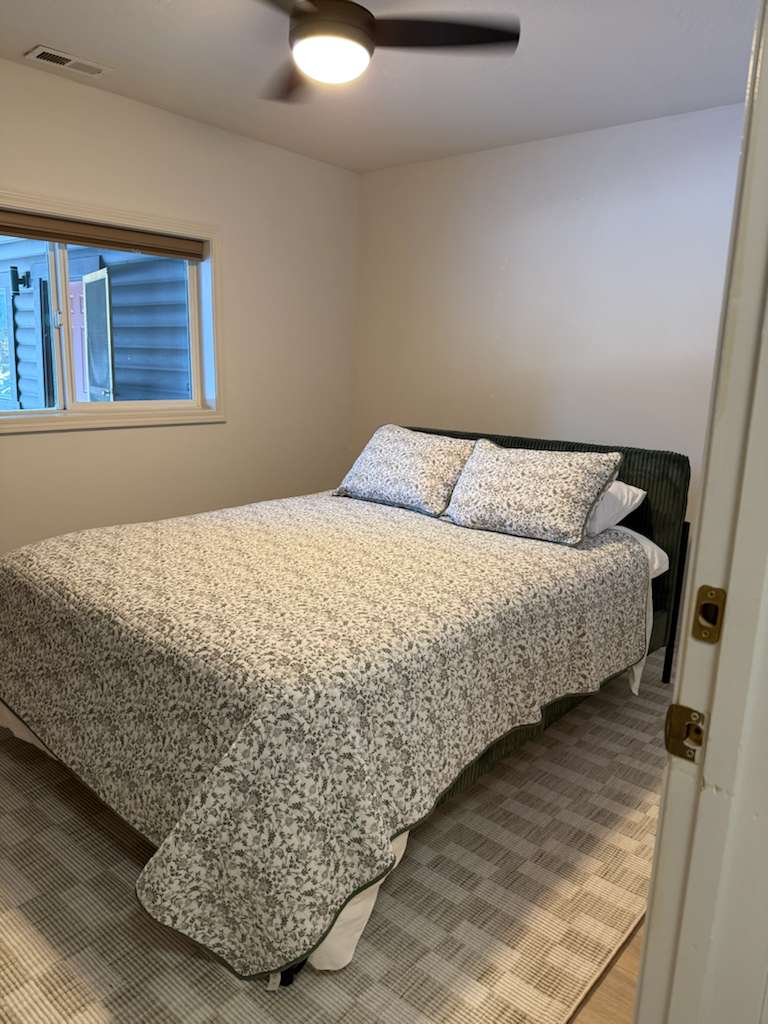 Spacious primary bedroom featuring a comfortable king bed, soft linens, and a relaxing atmosphere for a great night’s sleep.